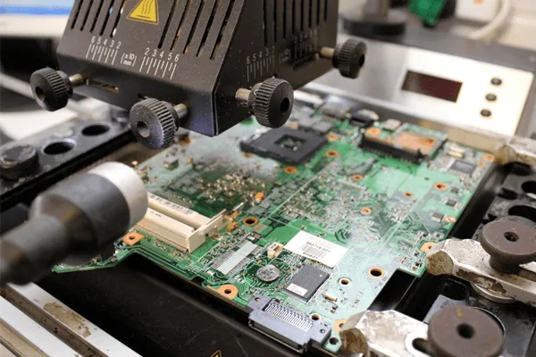 Board rework equipment positioned over a motherboard