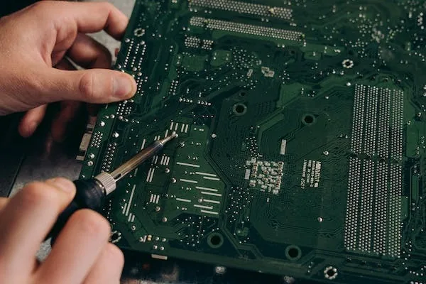 Technician testing a laptop motherboard